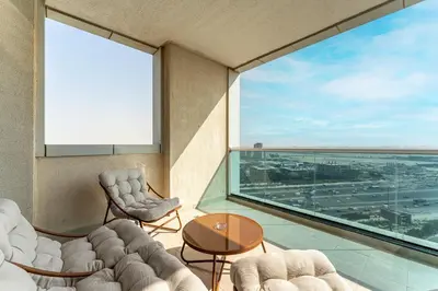 a room with a large window with chairs and a table at HAVN - Studio in Al Jawhara, JVT in Dubai