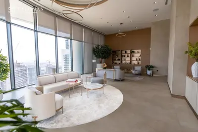 an office lobby with white furniture and large windows at Luxury 1BR Burj Khalifa & Flamingo Sanctuary Views in Dubai