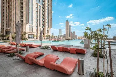 a group of orange chairs and a pool in a city at Luxury Leisure Massive Pool Oasis in Amna Tower in Dubai