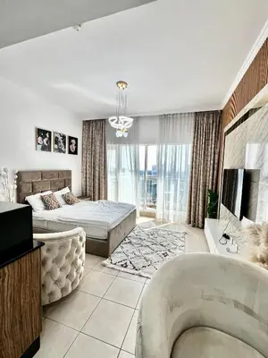 a bedroom with a bed and a couch and a tv at Spacious Modern High Floor Independent Studio Downtown in Dubai