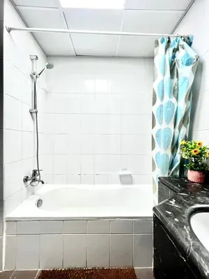 a bathroom with a bath tub and a sink at Spacious Modern High Floor Independent Studio Downtown in Dubai