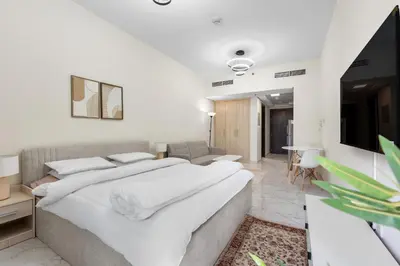 a bedroom with a large bed and a television at Brand New Designer Space with All Modern Amenities in Dubai