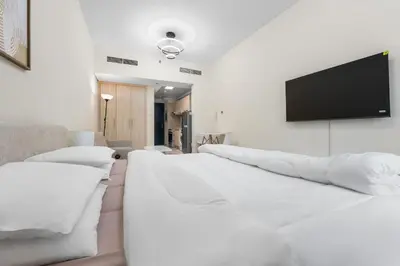 a living room with white furniture and a flat screen tv at Brand New Designer Space with All Modern Amenities in Dubai