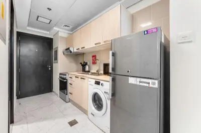 a kitchen with a refrigerator and a washing machine at Brand New Designer Space with All Modern Amenities in Dubai