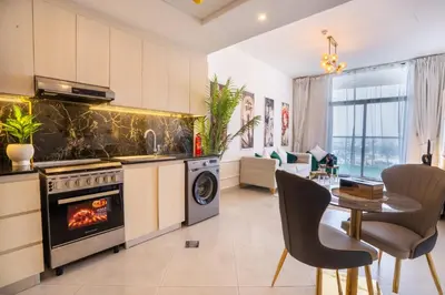 a kitchen and living room with a stove and a table at Luxury 1 Bedroom with Pool Dubai Frame Museum View in Dubai