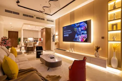 a living room with a couch and a tv on a wall at Luxury 2BHK in DownTown with Burj Khalifa View Imperial 2415 in Dubai