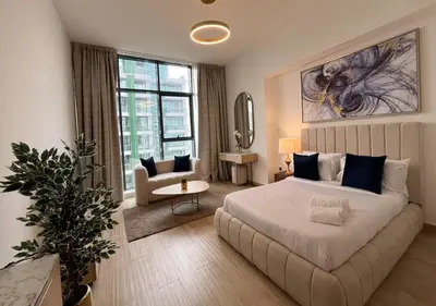 a bedroom with a large bed and a chair in it at City Forest Studio in JVC in Dubai