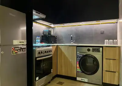 a kitchen with a stove and a washing machine at City Forest Studio in JVC in Dubai