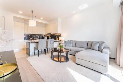 a living room with a couch and a table at Panoramic Dubai Water Canal Views 1BR with Seamless Access to Marina Mall, Steps from the Tram, The Address Residences, Dubai Marina by Deluxe Holiday Homes in Dubai