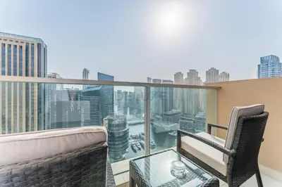 a balcony with two chairs and a glass table at Panoramic Dubai Water Canal Views 1BR with Seamless Access to Marina Mall, Steps from the Tram, The Address Residences, Dubai Marina by Deluxe Holiday Homes in Dubai