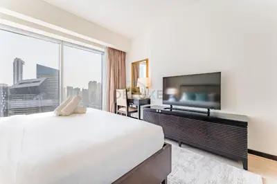 a bedroom with a large bed and a flat screen tv at Panoramic Dubai Water Canal Views 1BR with Seamless Access to Marina Mall, Steps from the Tram, The Address Residences, Dubai Marina by Deluxe Holiday Homes in Dubai