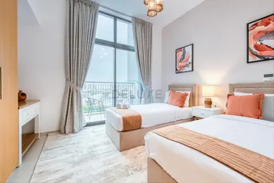 two beds in a room with a window at Fresh 2BR at Mudon Views 4, Dubailand by Deluxe Holiday Homes in Dubai