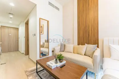 a living room with a couch and a table at Studio Near Meydan Racecourse and Golf Club with Convenient Access to Al Meydan Road and Dubai Top Attractions, Azizi Riviera 29, Al Merkadh by Deluxe Holiday Homes in Dubai