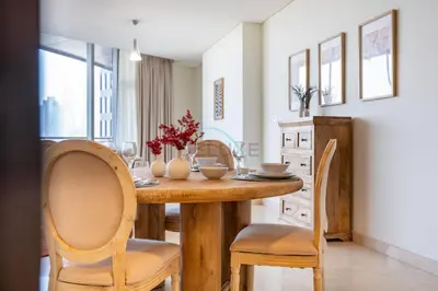 a dining room with a wooden table and chairs at Located Near Museum of the Future and Index Mall, Just a few Minutes Drive from Burj Khalifa and Dubai Mall - Sky Gardens, DIFC by Deluxe Holiday Homes in Dubai