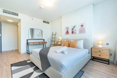 a bedroom with a large white bed and a desk at Located Near Museum of the Future and Index Mall, Just a few Minutes Drive from Burj Khalifa and Dubai Mall - Sky Gardens, DIFC by Deluxe Holiday Homes in Dubai