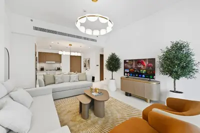 a living room with a couch and a tv at Newly Styled 1BD in Grand Bleu Beachfront, Fits 4 in Dubai