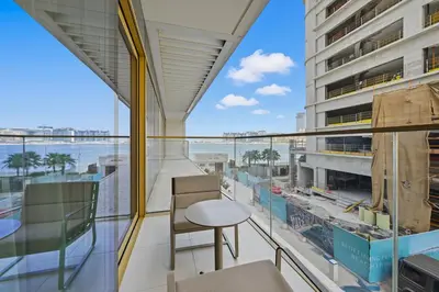 a balcony with a table and chairs and a view of the ocean at Newly Styled 1BD in Grand Bleu Beachfront, Fits 4 in Dubai