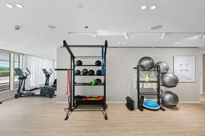 a room with a gym with weights and exercise equipment at Newly Styled 1BD in Grand Bleu Beachfront, Fits 4 in Dubai
