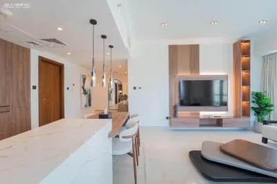 a kitchen with a counter and a tv in the background at Downtown Dubai- Modern upgraded 1 BR Plus Study Room with Luxury Interiors and Partial Fountain Views in Dubai