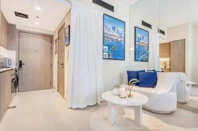 a living room with a white couch and a table at Urban Oasis - Modern Studio Retreat with City Views in Dubai