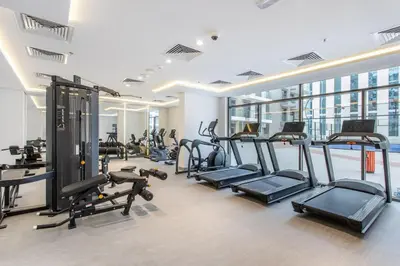 a gym with several treadmills and elliptical machines at Urban Oasis - Modern Studio Retreat with City Views in Dubai