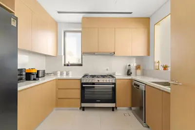 a kitchen with wooden cabinets and a stove at Luxury 4BR and Maid Room Townhouse Tilal Al Furjan in Dubai