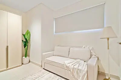 a white room with a chair and a window at Luxury 4BR and Maid Room Townhouse Tilal Al Furjan in Dubai