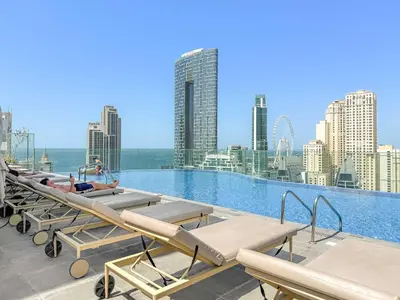 a pool with chaise lounges and a city skyline at Silkhaus Luxury 1BR at Marina Star in Dubai Marina in Dubai