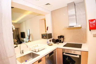 a small kitchen with a sink and a counter top at Stay in Style at Paramount Towers Spacious 1BR High Floor Luxury Furniture Branded Amenties in Dubai