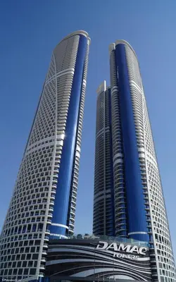 two tall skyscrapers in front of a blue sky at Stay in Style at Paramount Towers Spacious 1BR High Floor Luxury Furniture Branded Amenties in Dubai