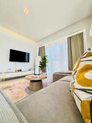 a living room with two beds and a flat screen tv at One bedroom Apartment in Dubai Marina next to the Marina Mall in Dubai