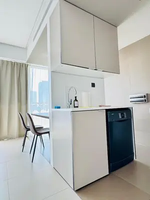 a kitchen with a white refrigerator and a table at One bedroom Apartment in Dubai Marina next to the Marina Mall in Dubai