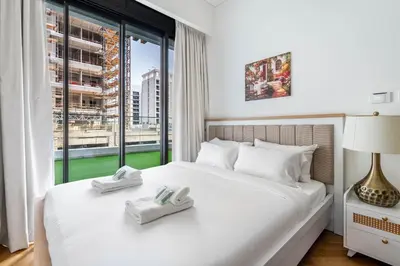 a bedroom with a white bed with a window at New Charming 2BR with Gym & Pool in Azizi Riviera in Dubai