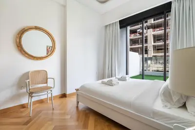 a bedroom with a bed and a chair and a window at New Charming 2BR with Gym & Pool in Azizi Riviera in Dubai