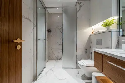 a bathroom with a toilet and a glass shower at New Charming 2BR with Gym & Pool in Azizi Riviera in Dubai