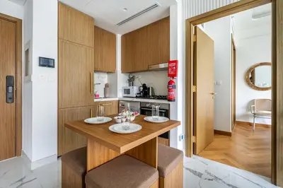 a kitchen with a wooden table with two chairs at New Charming 2BR with Gym & Pool in Azizi Riviera in Dubai