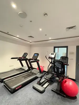 a gym with three exercise bikes and exercise balls at Spacious 1BR JVC Circle Mall at Your Doorstep in Dubai