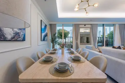 a dining room with a table and a couch at Palace Residence Beach Villa - Direct Beach Access in Dubai