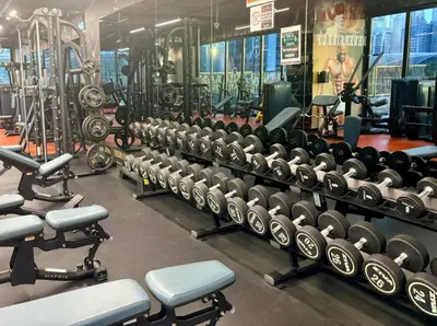 a gym with rows of dumbbells and weights at The Greendoor - Lake and Sea View, JLT in Dubai