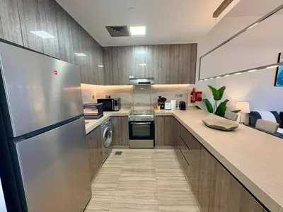 a large kitchen with a stainless steel refrigerator at The Greendoor - Lake and Sea View, JLT in Dubai