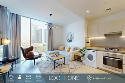 a kitchen and living room with a couch and a table at Locations l Elegant One Bedroom l City Views and Free Pool, Gym Access in Dubai