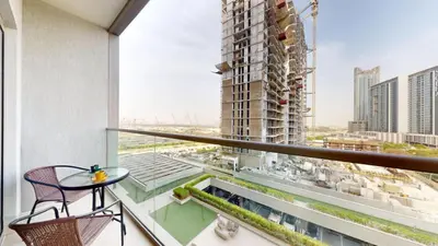 a balcony with a table and chairs on a building at Locations l Elegant One Bedroom l City Views and Free Pool, Gym Access in Dubai