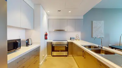 a kitchen with white cabinets and a sink at Locations l Chic 3 Bedroom l Burj and Fountain Views l Downtown Dubai in Dubai
