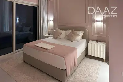 a bedroom with a large bed and a large window at Branded 2BR in Nakhlat Jumeira - Palm View in Dubai