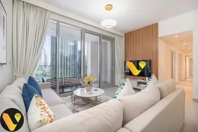 a large white living room with a large white couch at Vogue Downtown Forte near Dubai Mall and Burj Khalifa, Three-Bedroom Plus Kids room with Balcony and Fountain view, full access to all amenities in Dubai