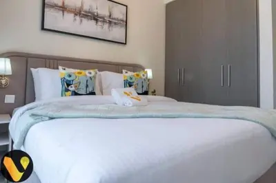 a bedroom with a large white bed with pillows at Vogue Downtown Forte near Dubai Mall and Burj Khalifa, Three-Bedroom Plus Kids room with Balcony and Fountain view, full access to all amenities in Dubai