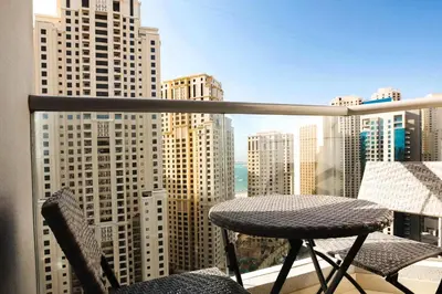 a balcony with a table and two chairs and a view of a city at Sansa Beach Home in Dubai
