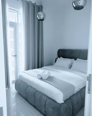 a bedroom with a large bed with two towels on it at Sansa Beach Home in Dubai