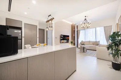 a kitchen and living room with a tv and a couch at Luxury Grande Suites by Hostiva - Full City View in Dubai