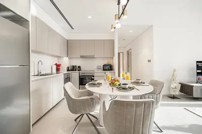 a kitchen with a table and chairs in a room at Luxury Grande Suites by Hostiva - Full City View in Dubai